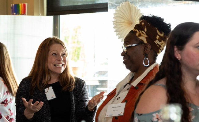 Two women smiling while networking