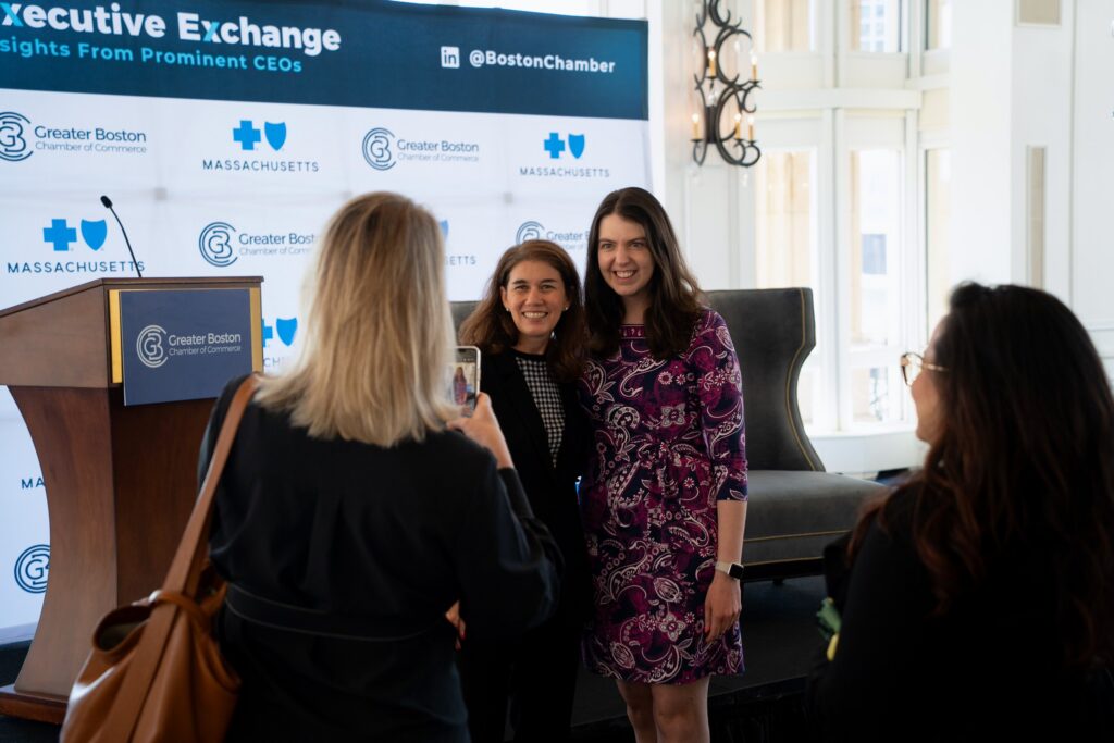A woman taking a photo with Lila Snyder, CEO of Bose, at the Greater Boston Chamber of Commerce's Executive Exchange event. 